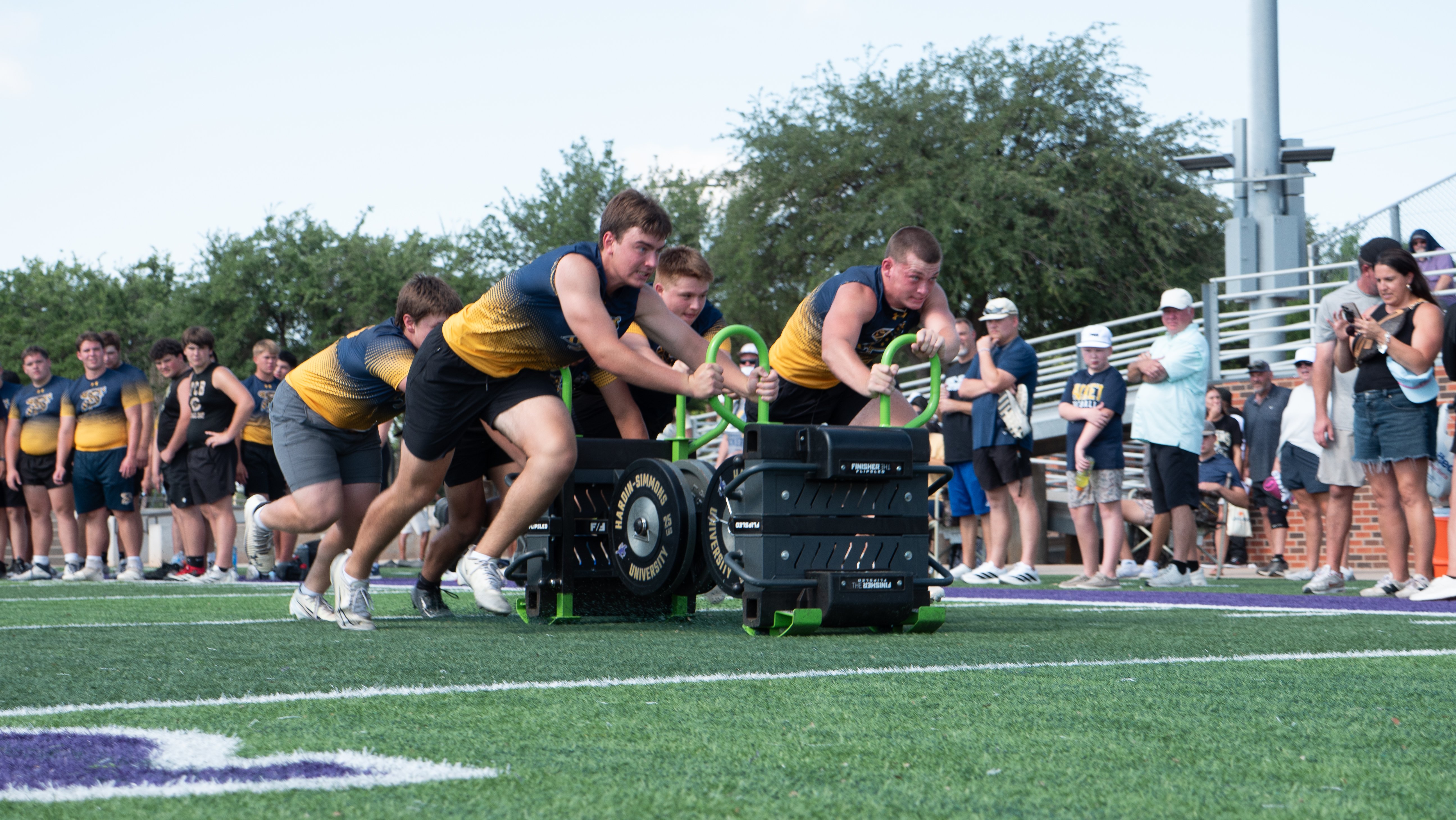 Football players pushing a football sled