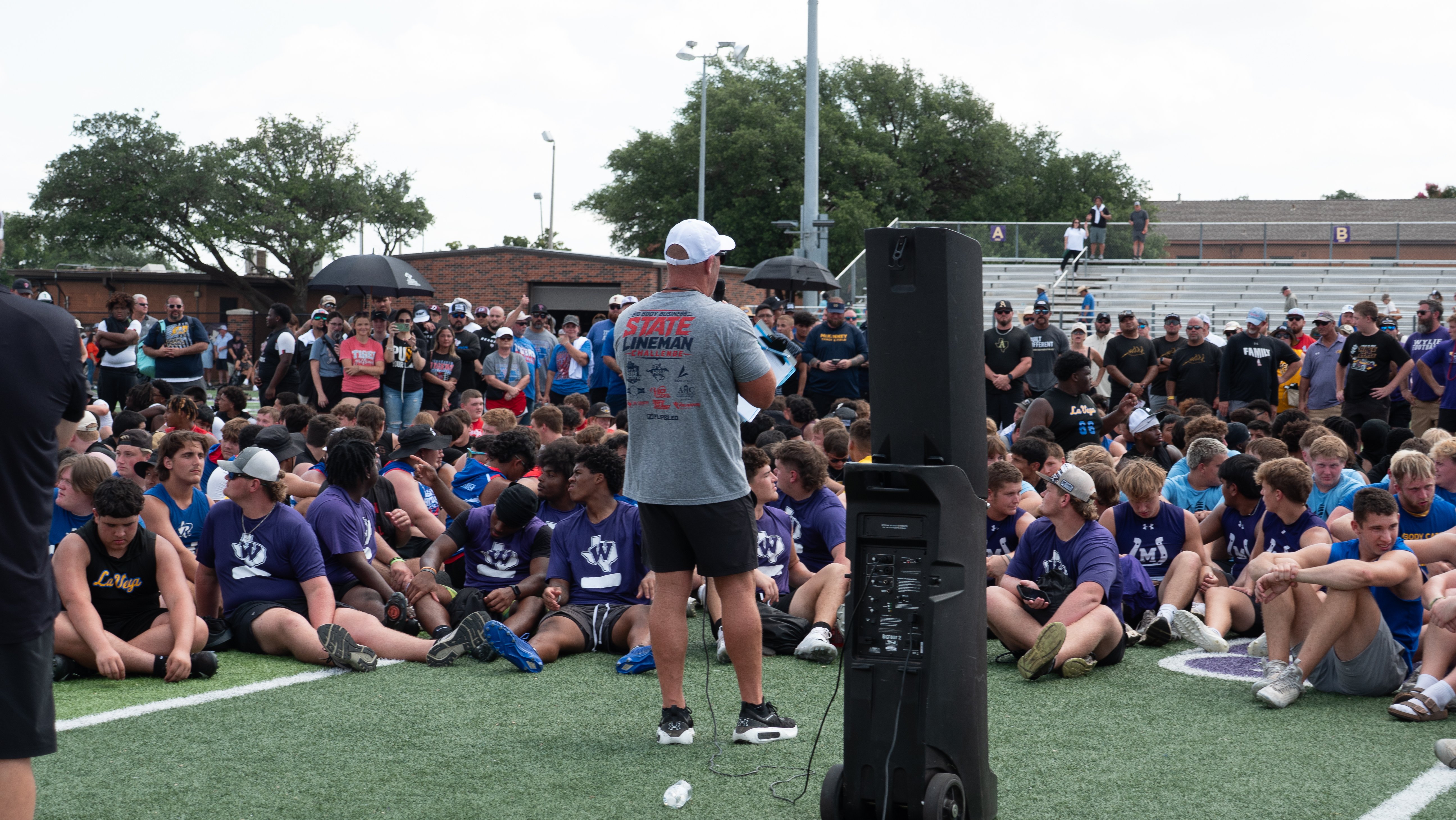 Coach addressing players at a football sled competition